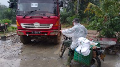 Photo of Terjang Hujan dan Lumpur, Praka HF Manalu Antarkan Nasi Buat Satgas dan Warga di Lokasi TMMD